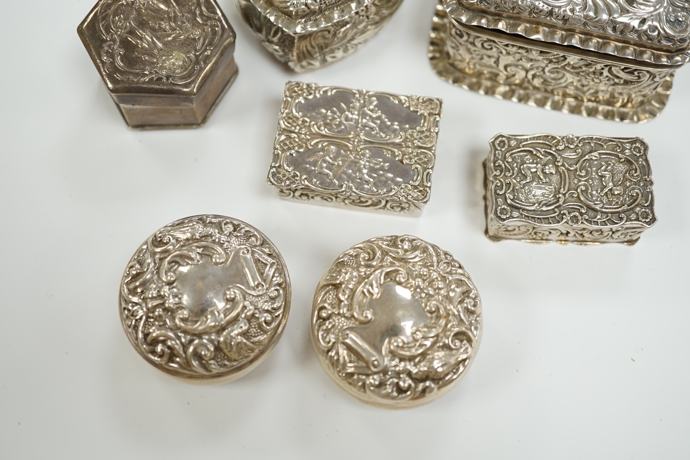 Six assorted early 20th century and later repousse silver boxes, largest 75mm and one similar white metal box.